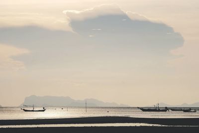 Sailboat on sea shore against sky