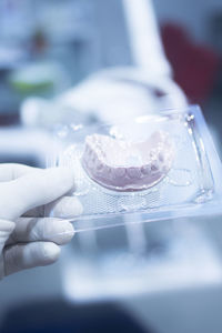 Close-up of hand holding dentures in hospital