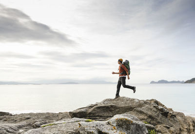 Man exploring the coast and jumping ove the rocks