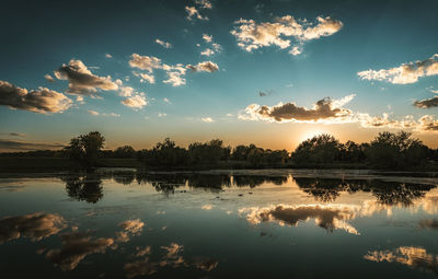 Scenic view of lake against sky at sunset