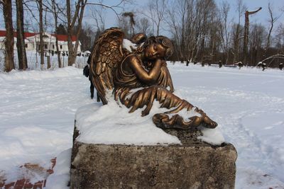 Statue on snow covered landscape