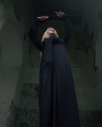 Low angle view of young woman standing in corridor