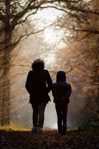 Rear view of couple walking in snow