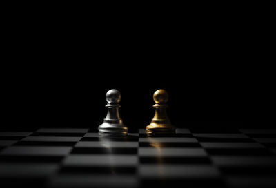 Close-up of chess pieces against black background