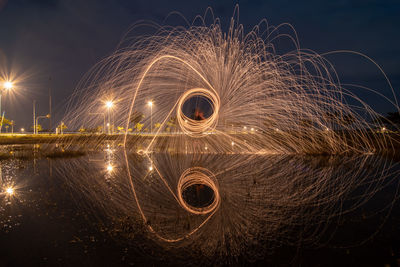 Person spinning wire wool in water during dusk 