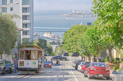 Vehicles on road by buildings in city