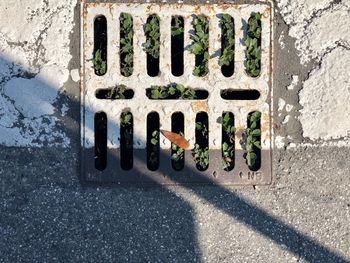 High angle view of metal grate on road