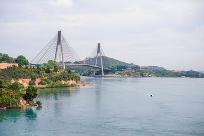 View of bridge over river against cloudy sky