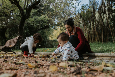 Mother playing with two children outdoors