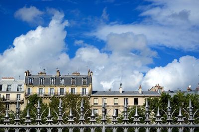 Low angle view of buildings against cloudy sky