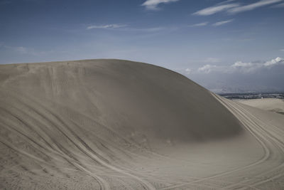 Sand dunes in desert against sky
