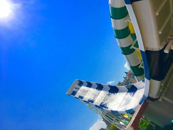 Low angle view of sunshade against clear blue sky