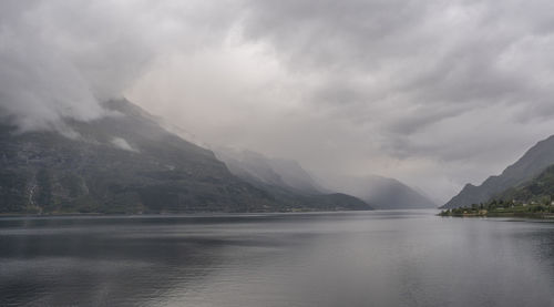 Scenic view of lake by mountains against sky