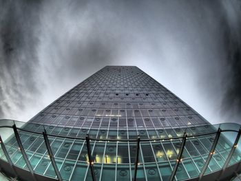Low angle view of modern building against cloudy sky