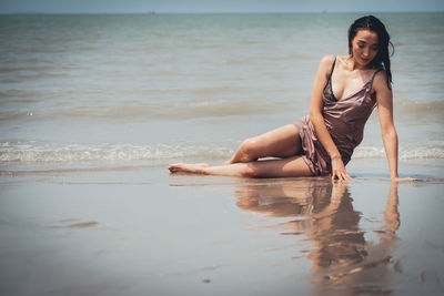 Young woman on wet sand at beach