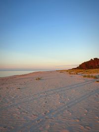 Scenic view of beach against clear sky during sunset