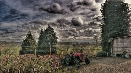 View of field against cloudy sky