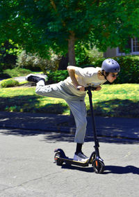 Low section of man riding electric scooter on road