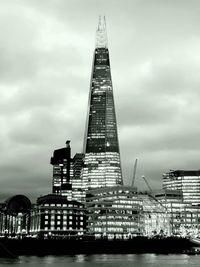 Low angle view of skyscrapers against cloudy sky