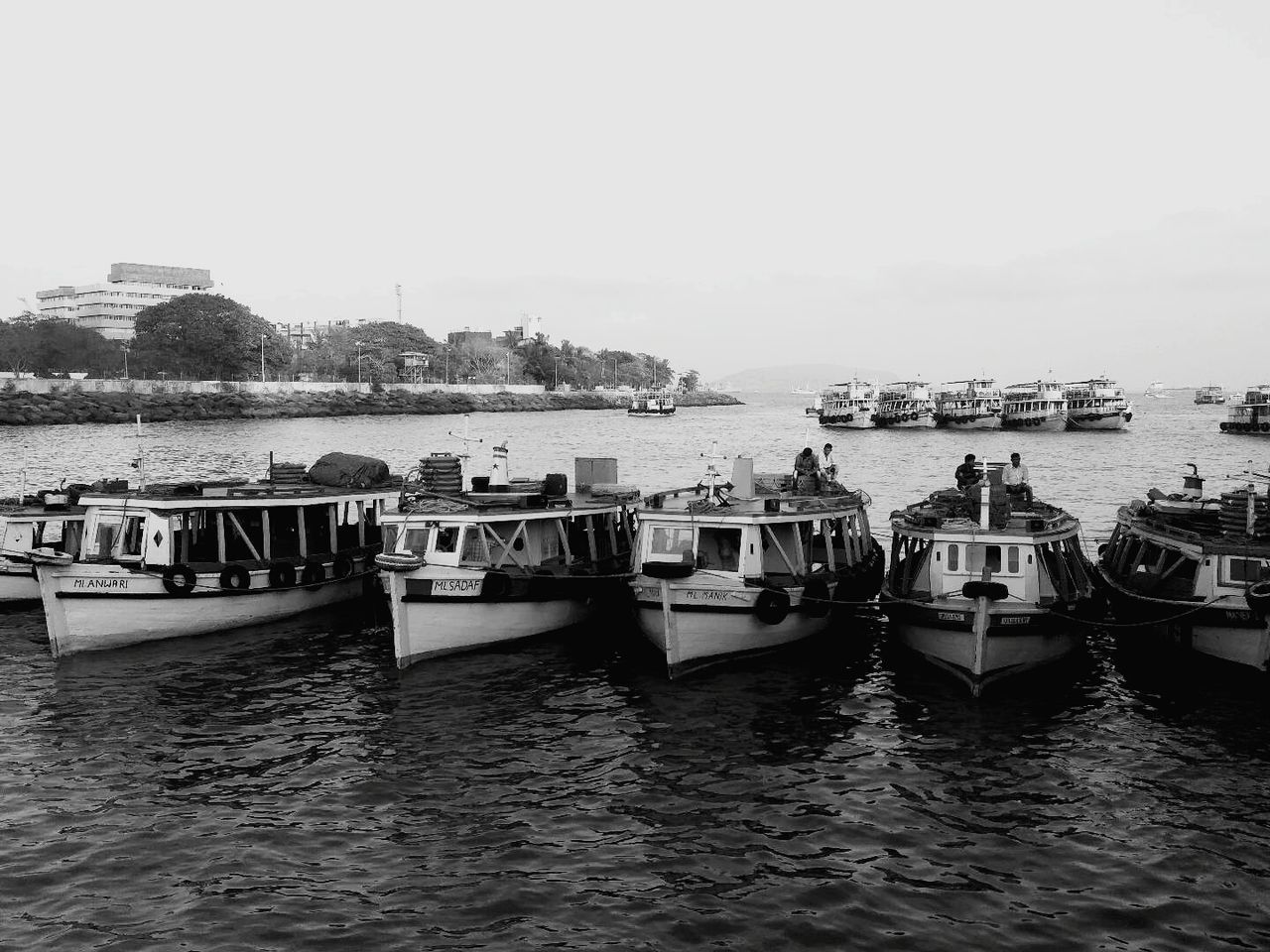 BOATS MOORED IN RIVER AGAINST SKY