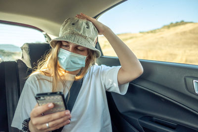 Midsection of woman holding umbrella in car