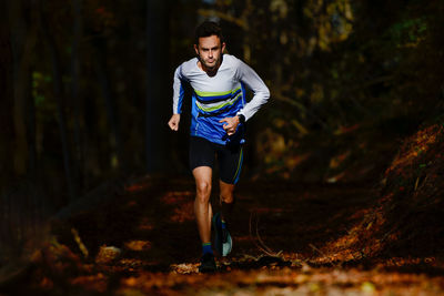 Full length of young man running in forest