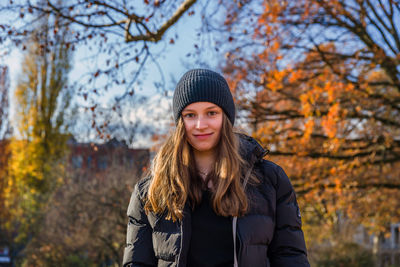 Portrait of beautiful young woman standing in park during autumn