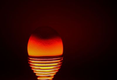 Close-up of illuminated light bulb against black background