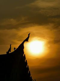 Low angle view of silhouette temple against sky during sunset