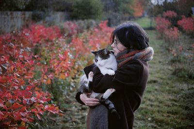 Side view of woman with dog on field