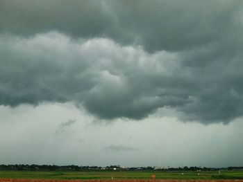 Scenic view of grassy field against cloudy sky