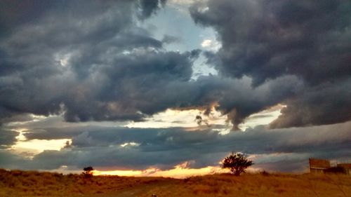 Low angle view of storm clouds over field