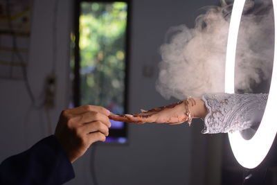 Midsection of man holding cigarette