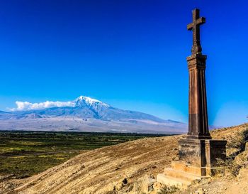 Cross on mountain against blue sky