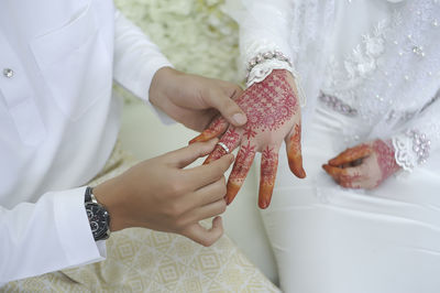 Midsection of couple holding hands