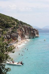 High angle view of people on sea shore against sky