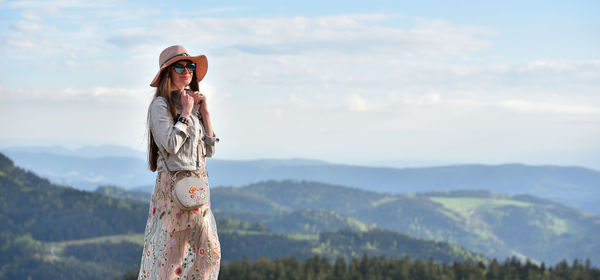 Woman standing on mountain against sky