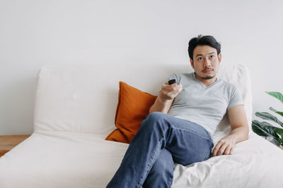 Young woman sitting on sofa at home