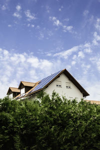 Low angle view of house and trees against sky