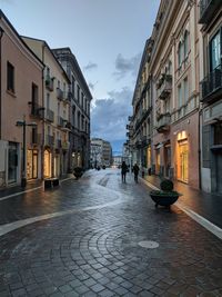 People walking on street amidst buildings in city