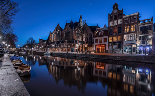 Reflection of buildings in canal at dusk