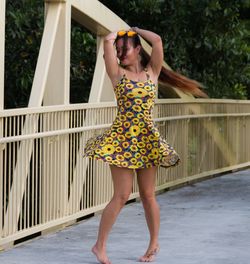 Rear view of woman standing against railing