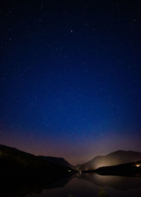 Scenic view of mountains against sky at night