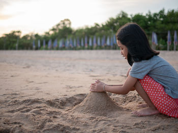 Side view of woman sitting on beach