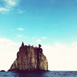 Rock formations by sea against sky