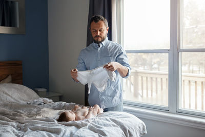 Full length of a man sitting on bed