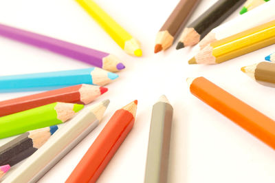 High angle view of colored pencils on white background