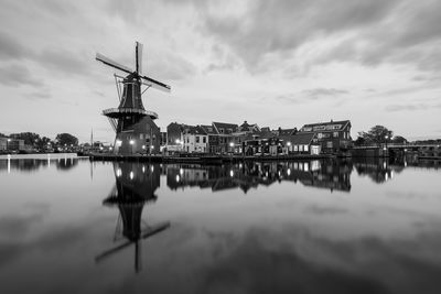 Reflection of built structure in water against sky