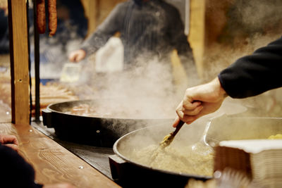 Cropped hand of man preparing food in workshop