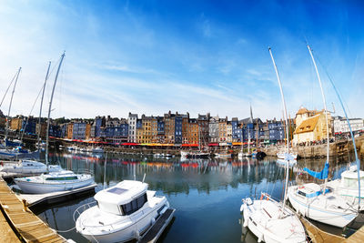 Boats moored in harbor at city